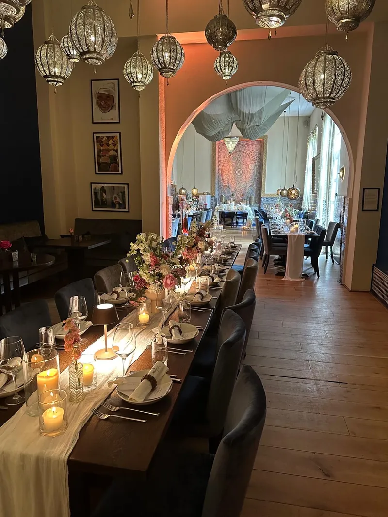 Festively set long table at ArabesQ, view through the archway