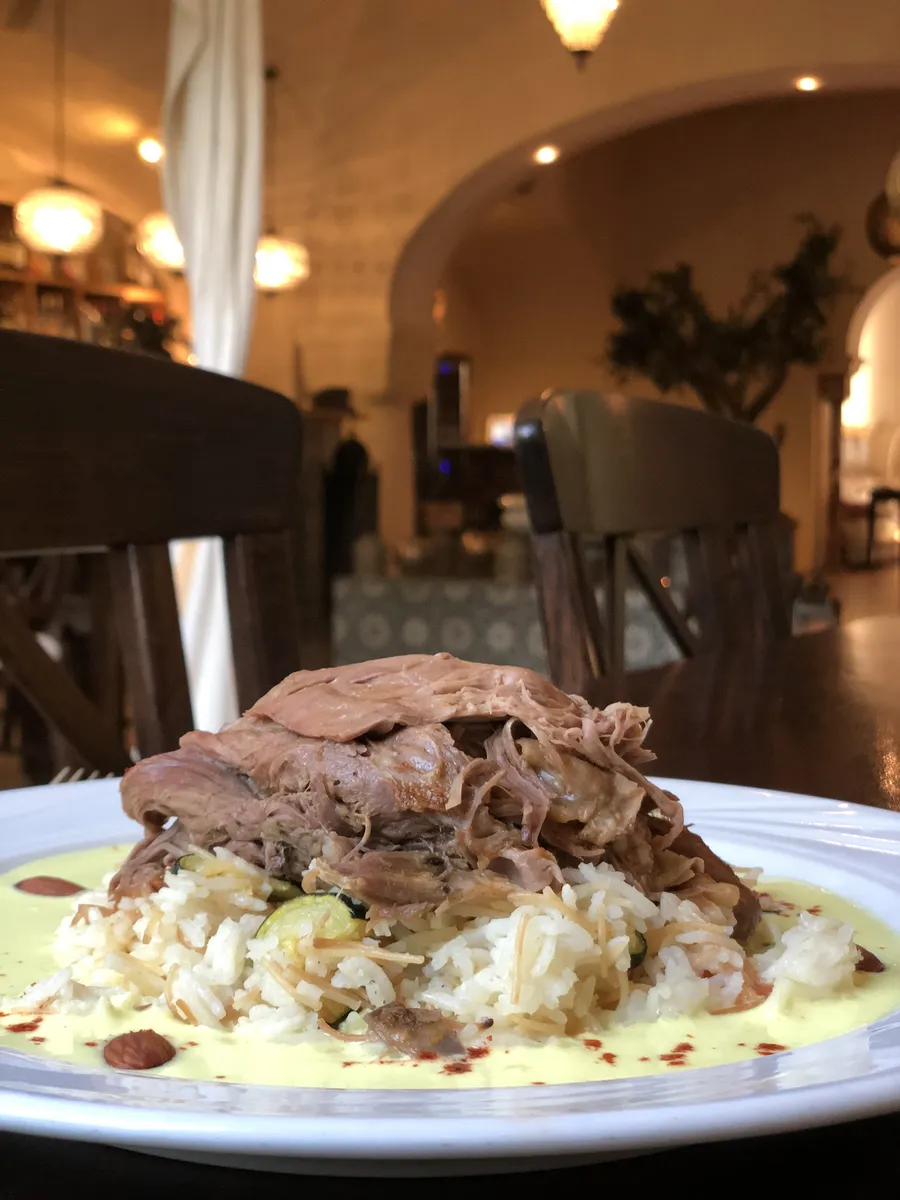 Lang geschmortes Lammschulterfleisch auf Maklube, dem traditionellen arabischen Gemüsereis, im ArabesQ serviert